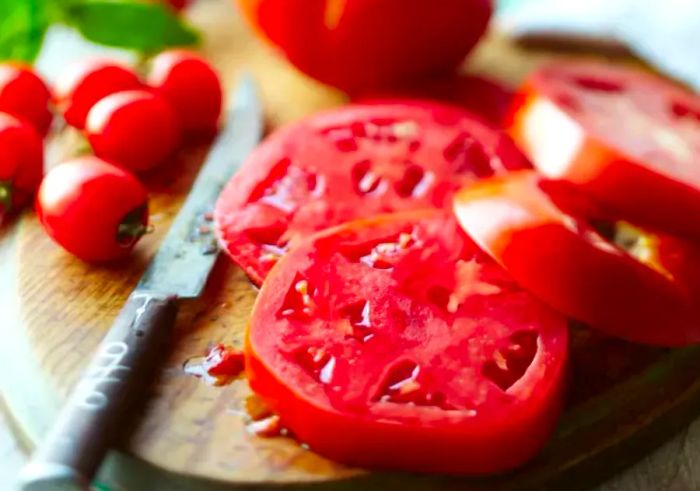 Tomato slices placed neatly on a cutting board