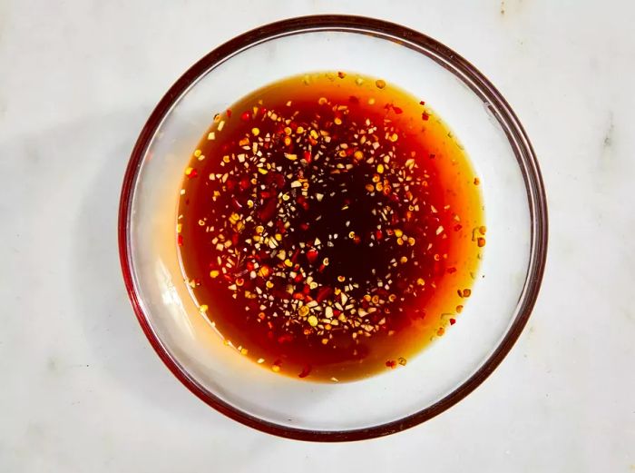 Bird's-eye view of a fish sauce mixture in a clear glass bowl.