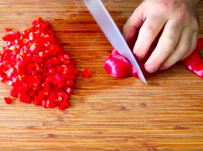 Chef John chopping a bell pepper into cubes.