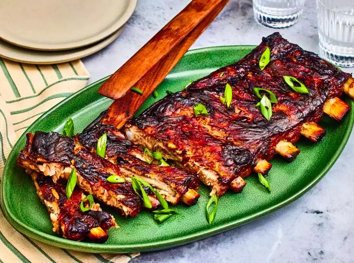 A serving platter with Chinese spareribs, garnished with freshly sliced green onions