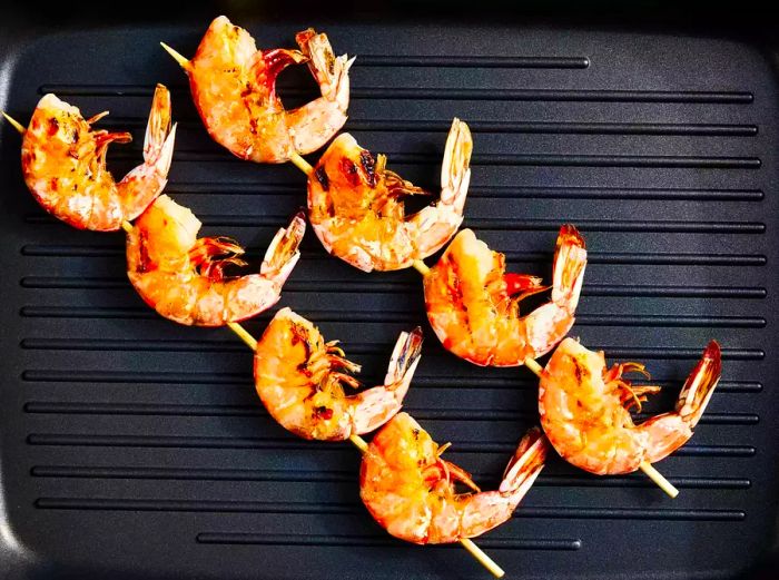 Aerial view of shrimp skewers cooking on the grill.