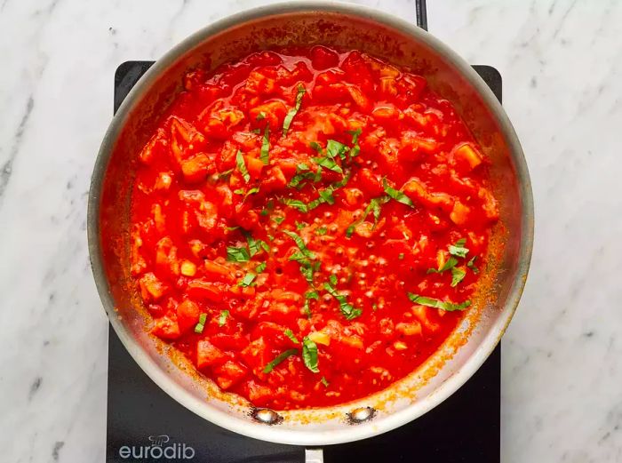 An aerial view of tomato sauce simmering in a saucepan.