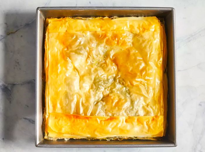 Bake the spinach pie until the phyllo dough is golden brown and crispy.