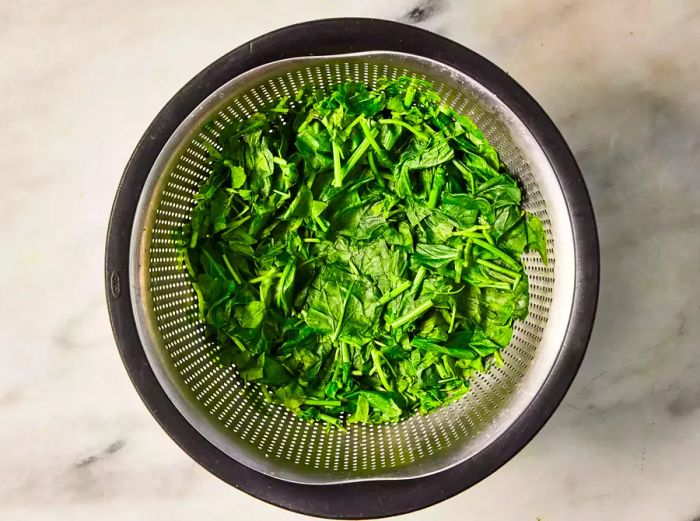 A colander filled with drained spinach