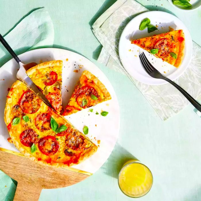 Sliced vegetable quiche arranged in triangular portions on a white serving plate