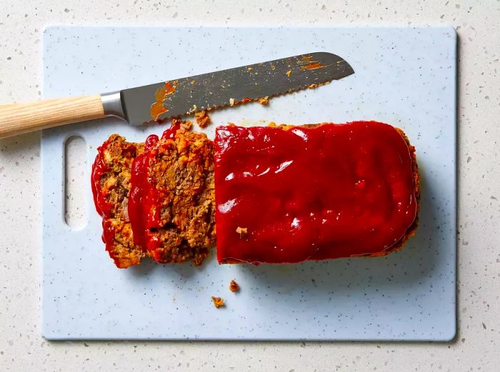 Slices of Stovetop Stuffing Meatloaf on a cutting board with a knife