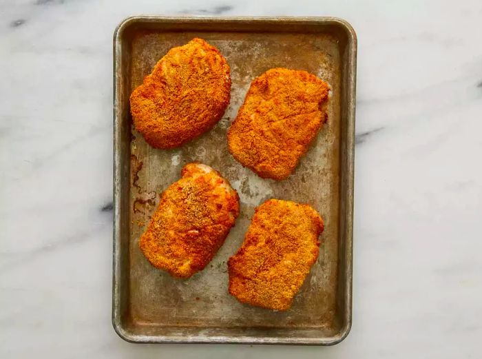 Top view of pork chops cooking in the air fryer basket