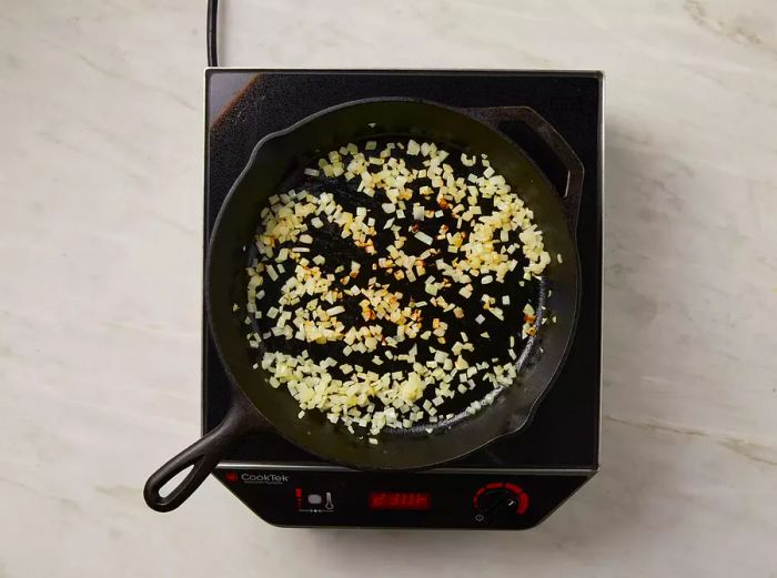 View from above of onions cooking in a skillet.