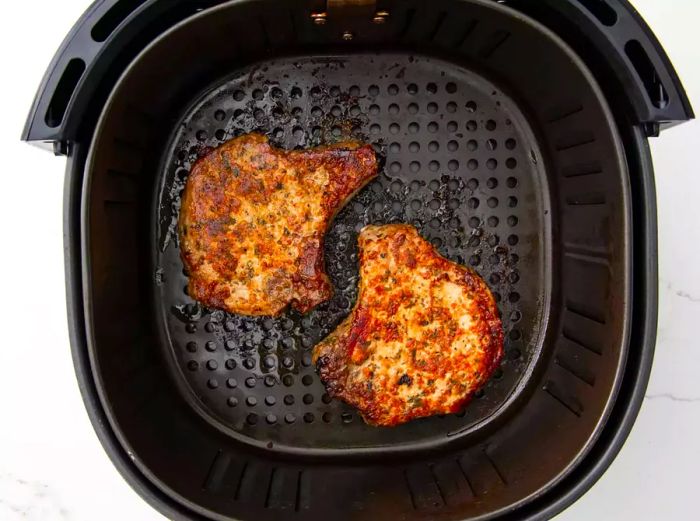 Top-down view of breaded pork chops in the air fryer