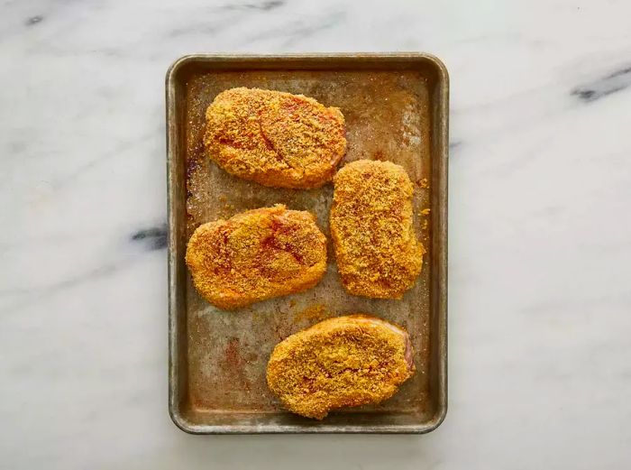 Top view of the breaded pork chops arranged on a tray