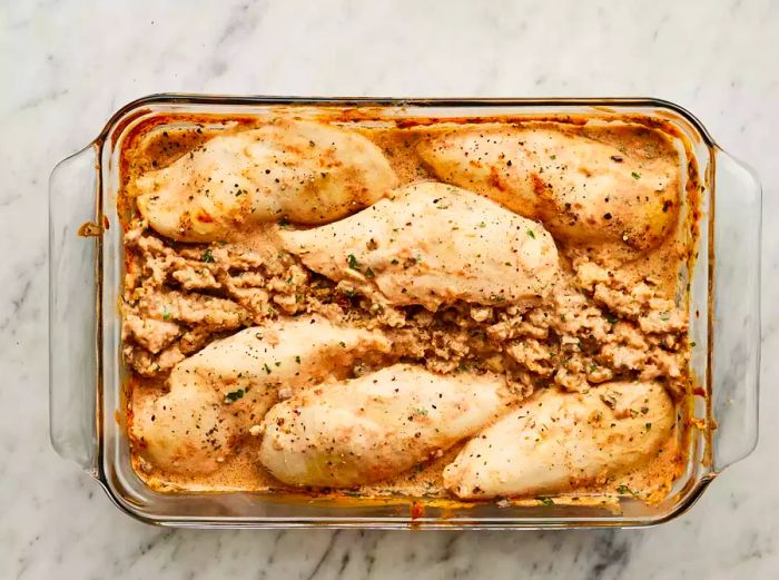 The casserole is baked until the chicken is fully cooked and no longer pink inside.