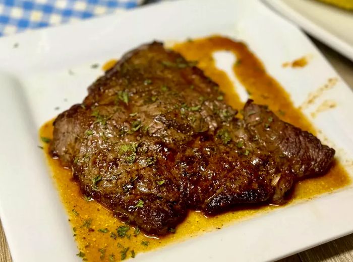 Minute steak topped with fresh herbs in a rich butter sauce