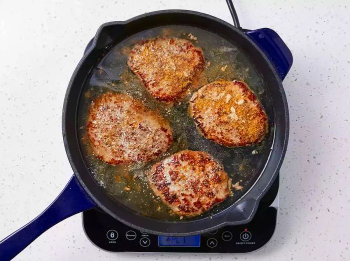 Water added to the skillet, just covering the steaks.