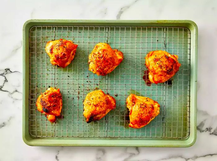 A top-down view of crispy, golden-brown baked chicken on a cooling rack