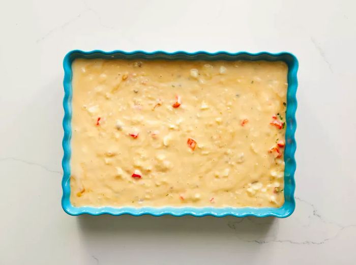 The creamy mixture is added to the baking dish.