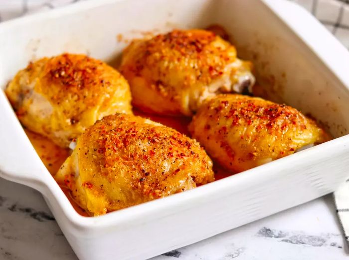 Baked chicken thighs in a white casserole dish