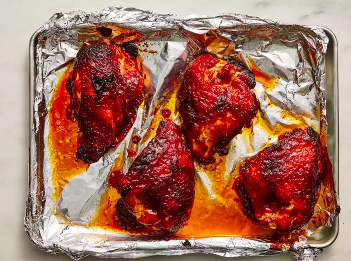 Chicken breasts placed on a foil-lined baking sheet