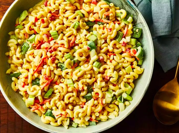 A close-up overhead shot of a generous bowl of traditional macaroni salad.