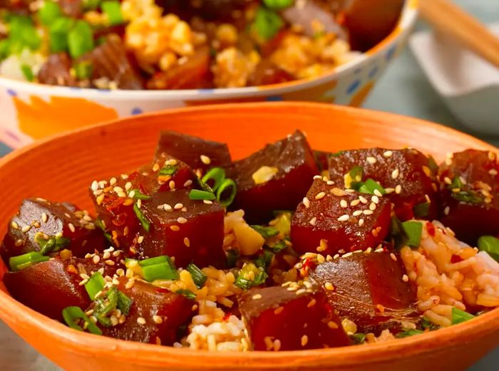 a close-up, medium-angle shot of ahi tuna poke served with rice in an orange bowl