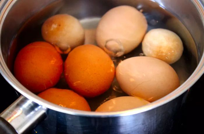 a saucepan with chicken eggs boiling and simmering water