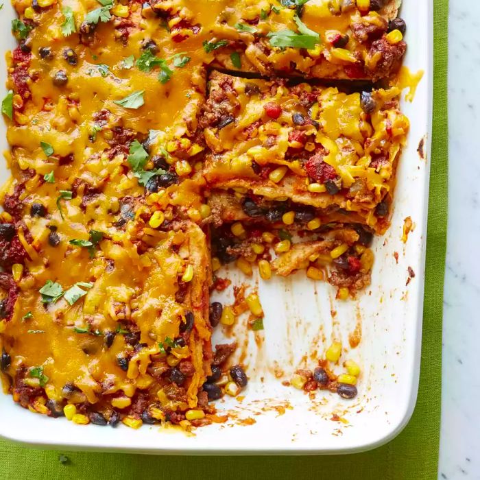 a white casserole dish filled with Mexican Quesadilla Casserole