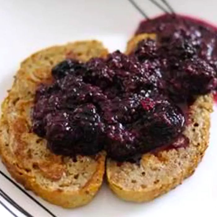 two slices of whole grain toast topped with homemade blackberry sauce