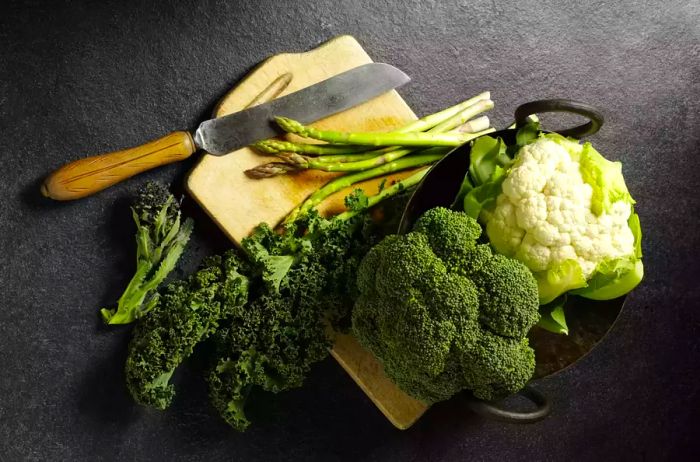 Fresh Broccoli, Cauliflower, and Asparagus on a Cutting Board