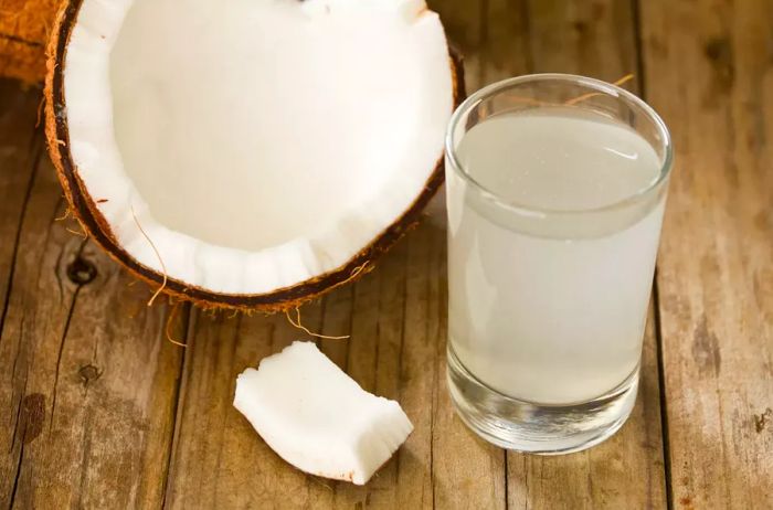 Coconut water and nuts on a wooden surface