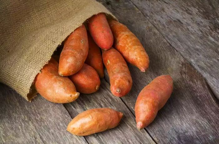 sweet potatoes spilling out of a burlap sack