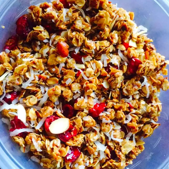 Overhead view of Stovetop Granola recipe with almonds, dried cranberries, and shredded coconut