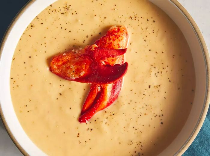 Looking down at a bowl of lobster bisque, topped with lobster claws