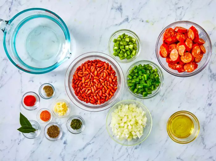 A top-down view of the measured and prepared ingredients for authentic red beans and rice.