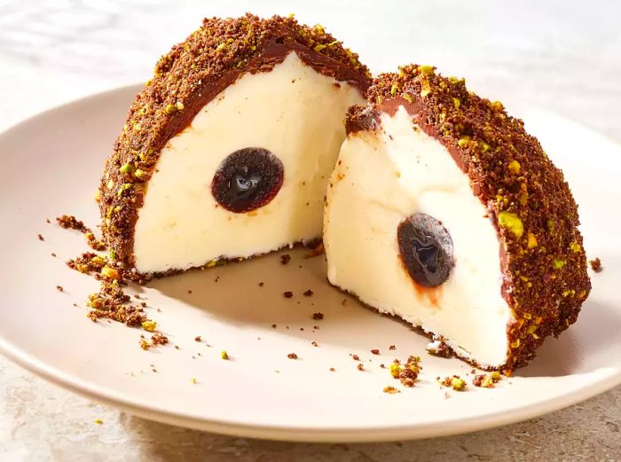 A halved Tartufo dessert served on a white plate