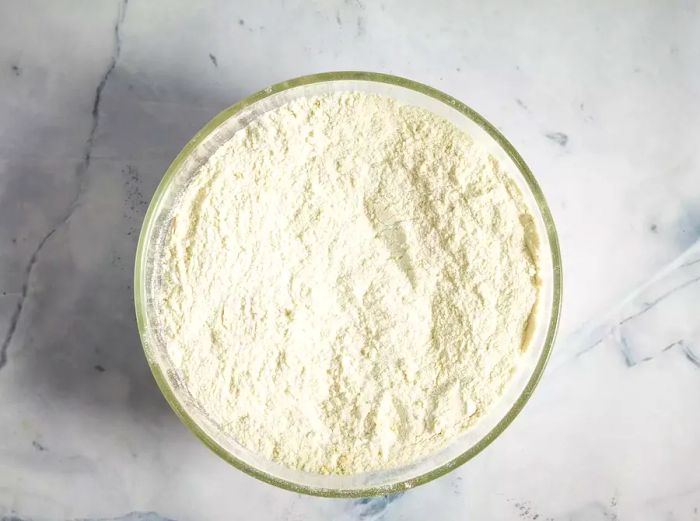 A glass bowl containing glutinous rice flour and green tea powder.