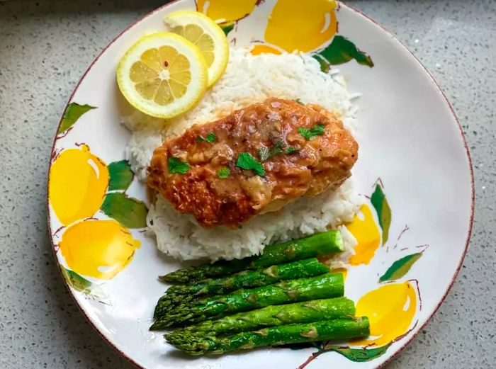 Katie Couric's lemon chicken served over rice with asparagus and a touch of lemon.