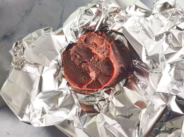 A top-down view of the red bean paste wrapped in aluminum foil.