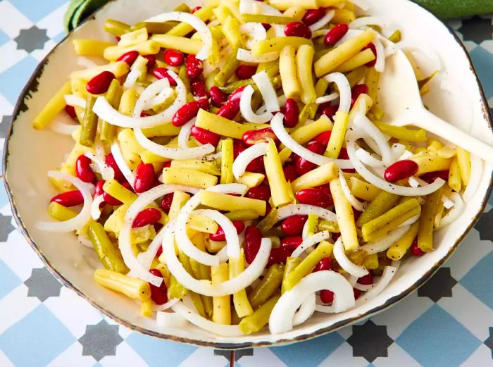 A high-angle shot of a bowl filled with three bean salad.