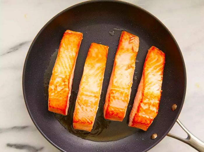 Salmon cooked on high heat, skin-side down until crisp.