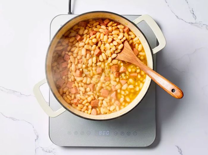 A large pot filled with ham and beans