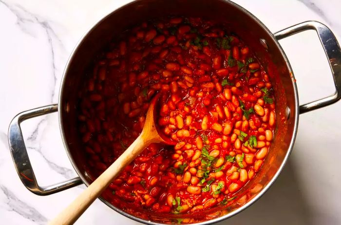 A large pot of pinto beans with Mexican-style seasonings, garnished with freshly chopped cilantro