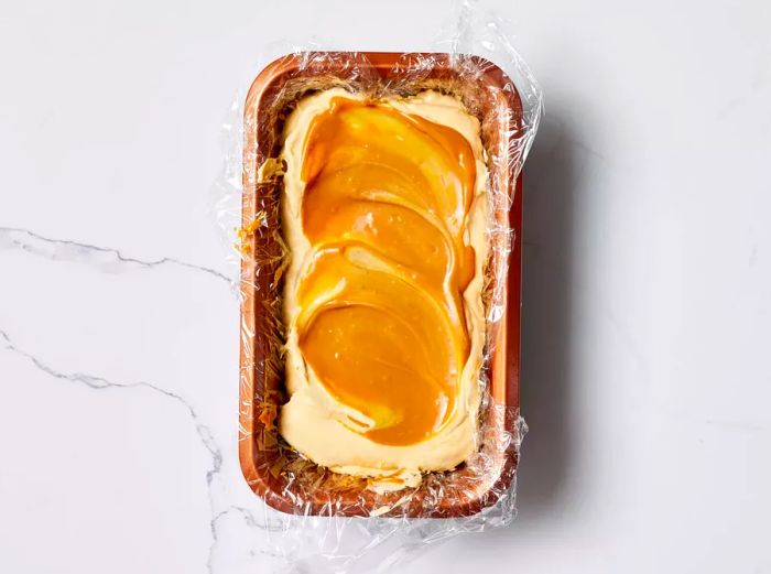 Dulce De Leche Ice Cream set in a loaf pan, wrapped in plastic