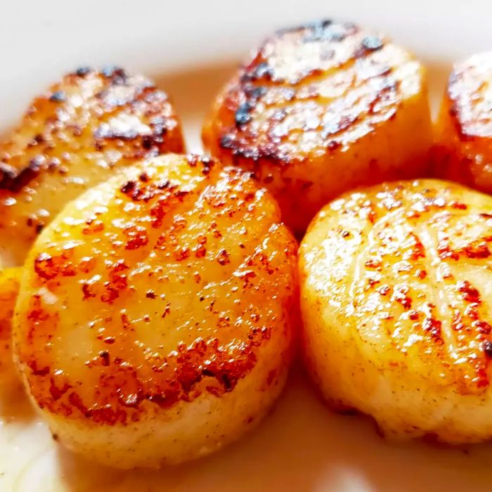 A close-up of garlic-lemon scallops served on a white plate