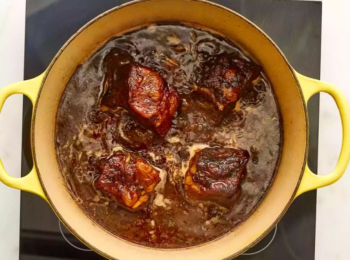 Beef short ribs simmering in the pot.