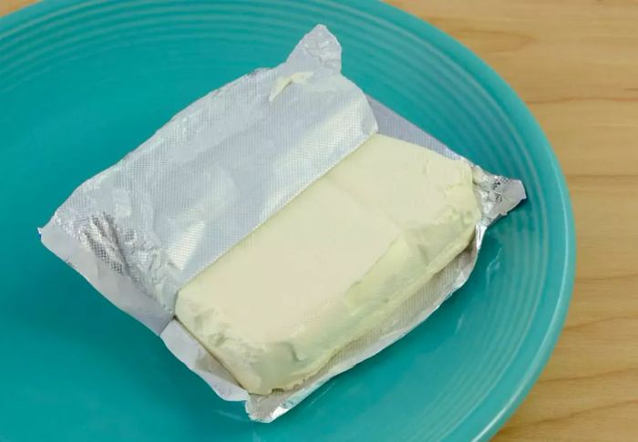 Block of cream cheese on a blue plate