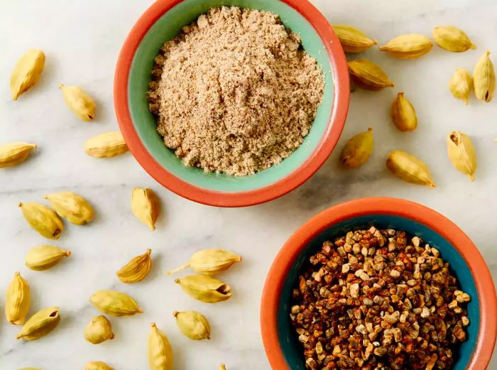 Three varieties of cardamom displayed in bowls.