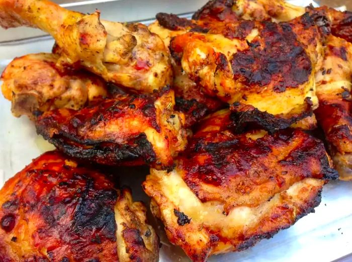 close-up of Grilled Lemon-Yogurt Chicken pieces with a beautifully browned, crispy skin