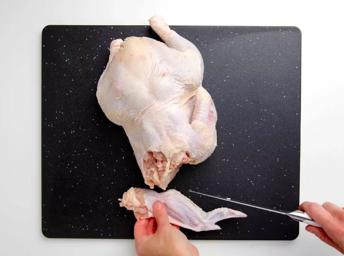 Detaching the wing from the whole chicken