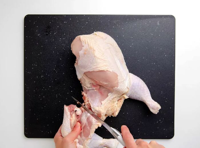 Cutting a whole chicken into parts