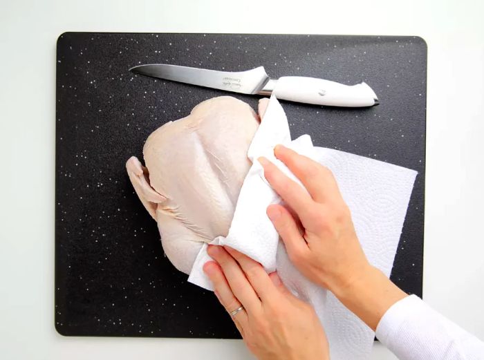 Use a paper towel to pat down the entire chicken