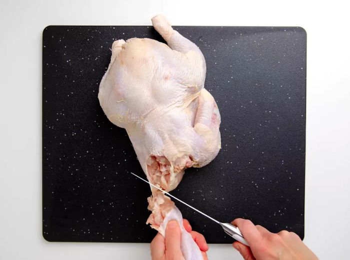 Removing the wing from the whole chicken